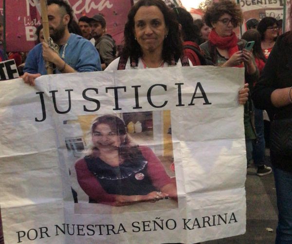 Docente de nivel inical con cartel que dice justicia por nuestra seño Karina